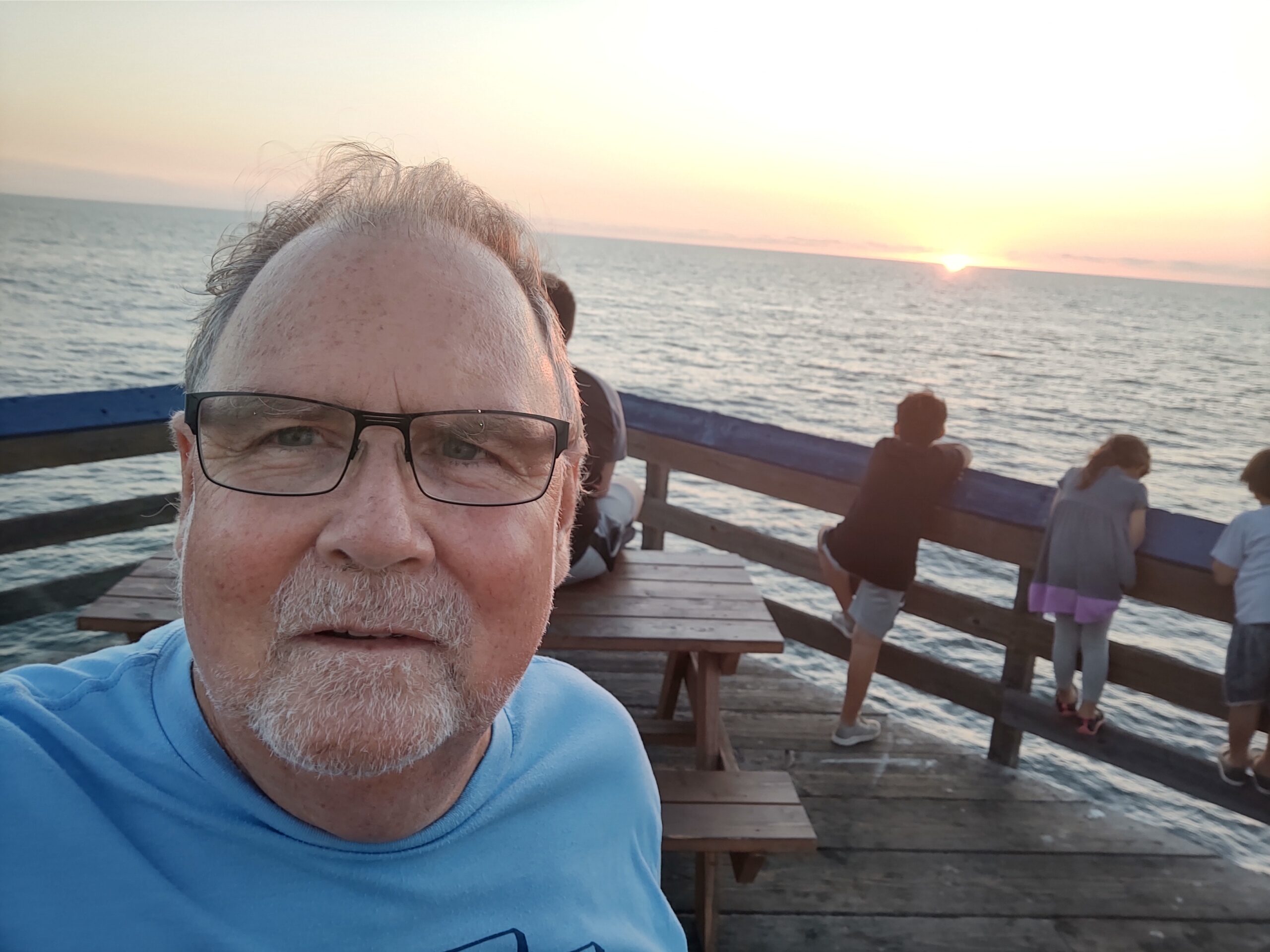 headshot image on ocean pier at sunset